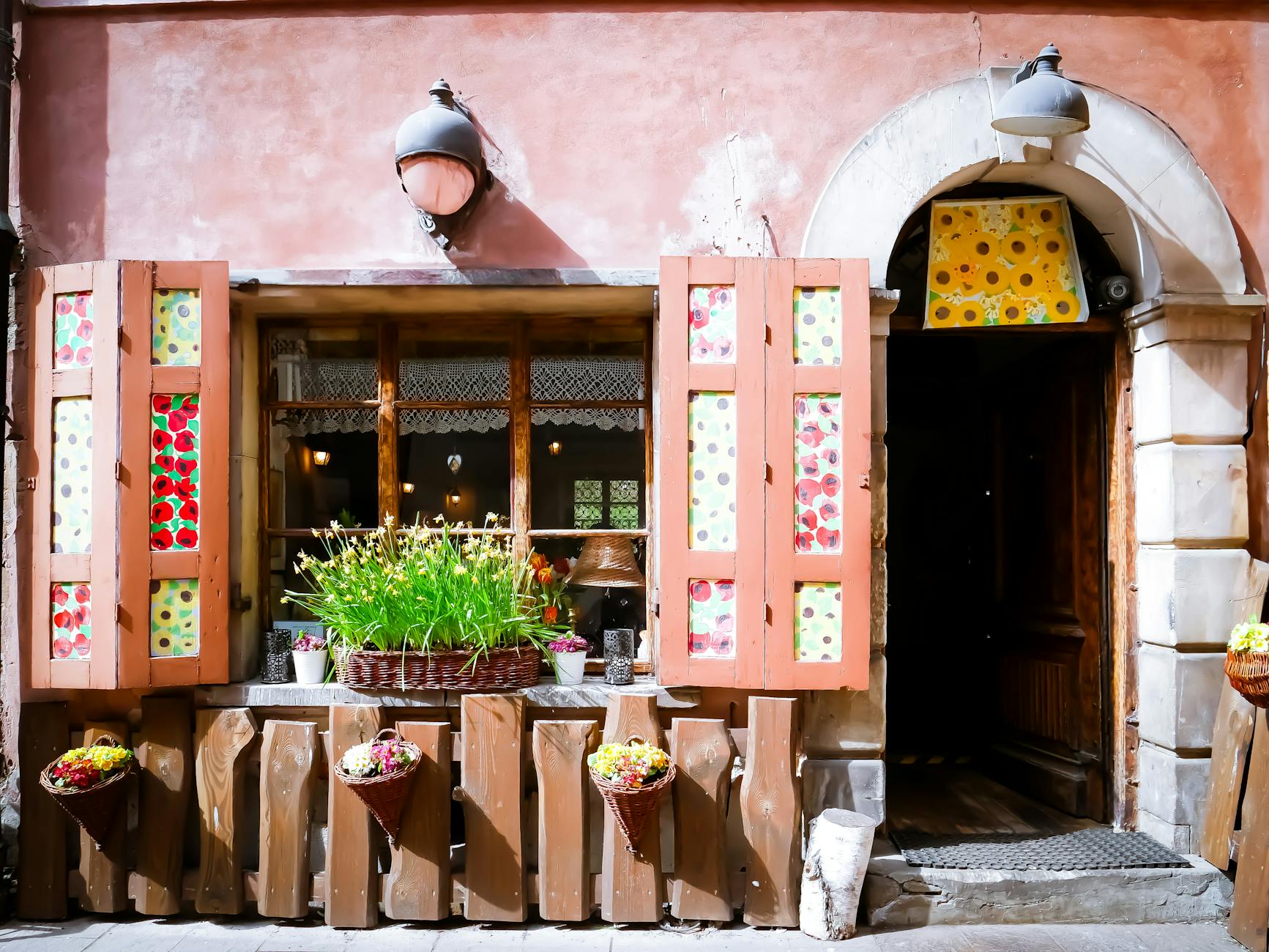 Przytulna kawiarnia z kolorowymi okiennicami i kwiatami na małej uliczce