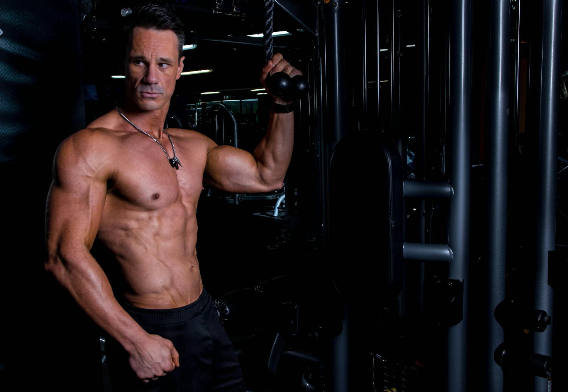 Mężczyzna o atletycznej sylwetce ćwiczy na siłowni w pomieszczeniu