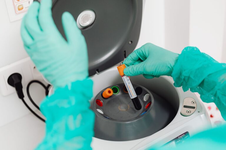 Technik laboratoryjny obsługuje wirówkę do analizy krwi
